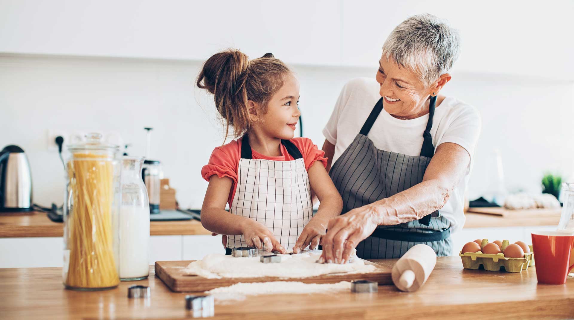 A child and older lady are preparing cookies for baking