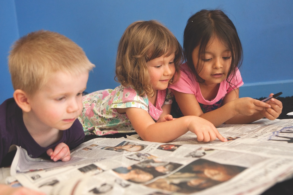 Children Reading a newspaper